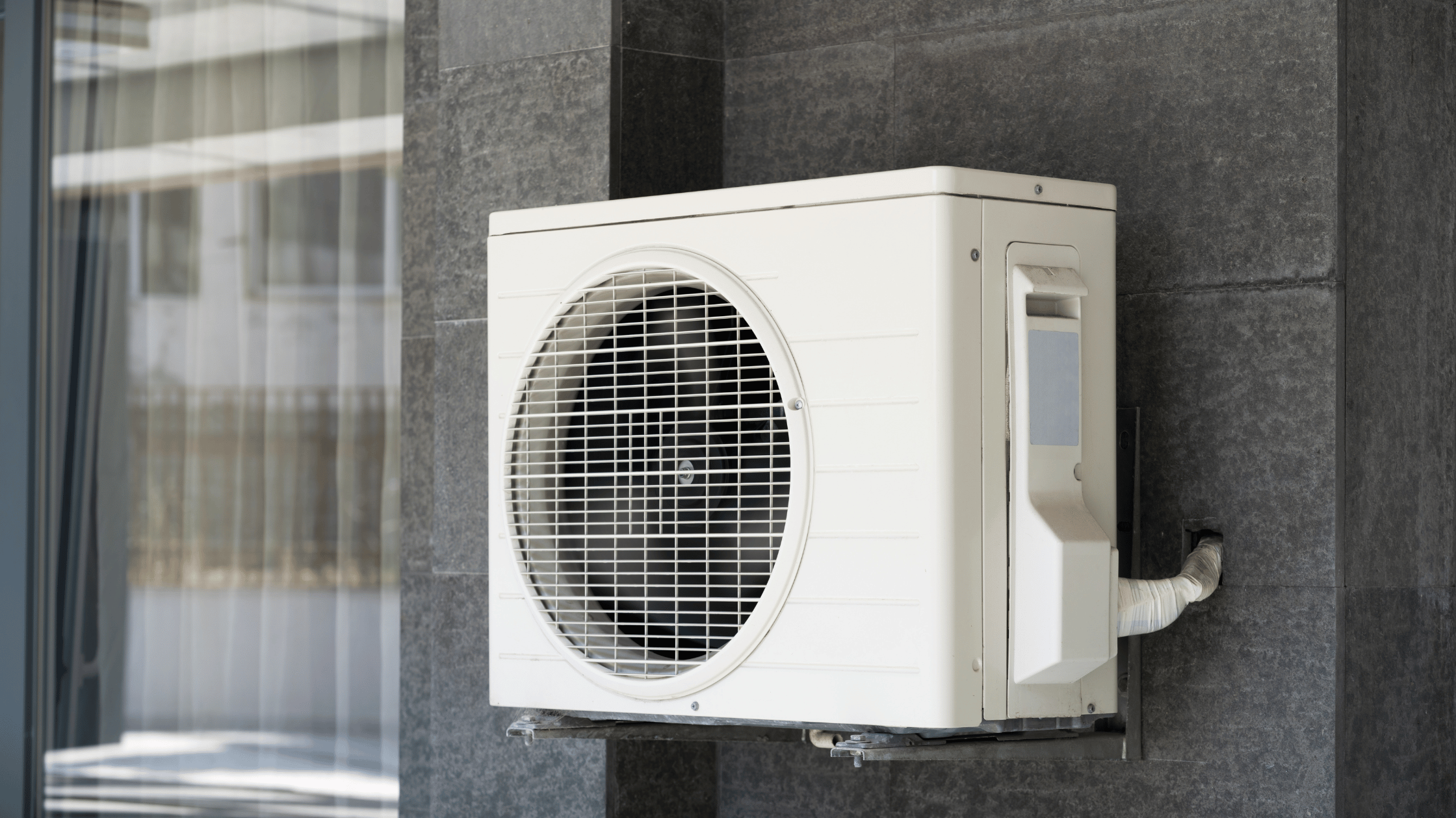 Thermopompe murale sur un mur de maison noir